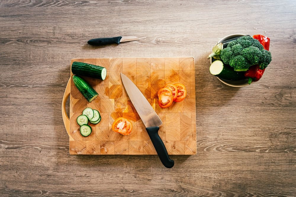 Slicing fresh vegetables on a wooden board